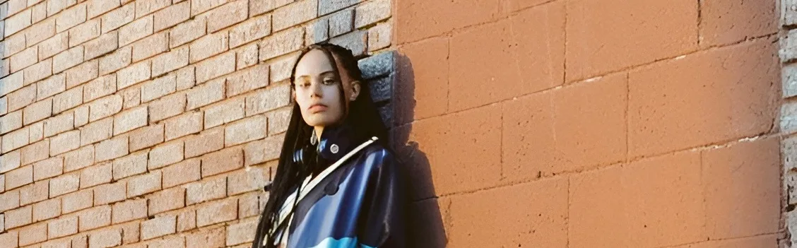 modelos usando roupas streetstyle em frente uma parede de tijolin