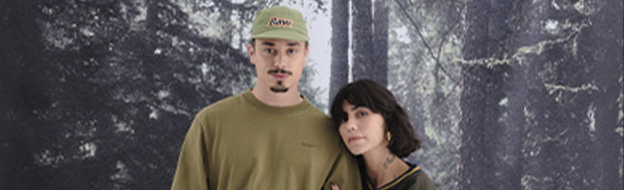 Casal posando em floresta com fundo sóbrio