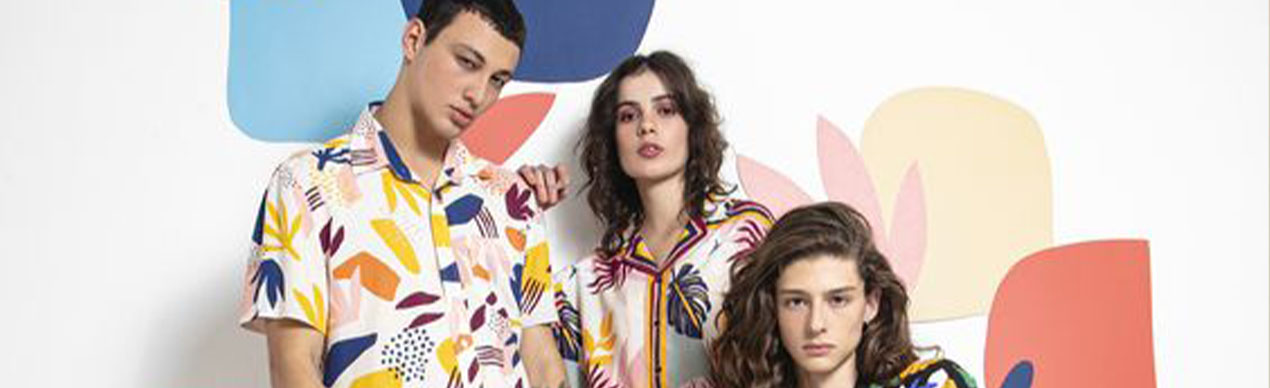 Três modelos com roupas coloridas em fundo artístico