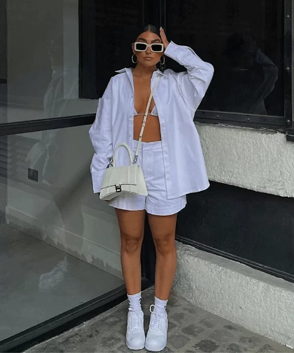modelo com look all white com camisa, bermuda, tênis e meias brancas bem streetstyle