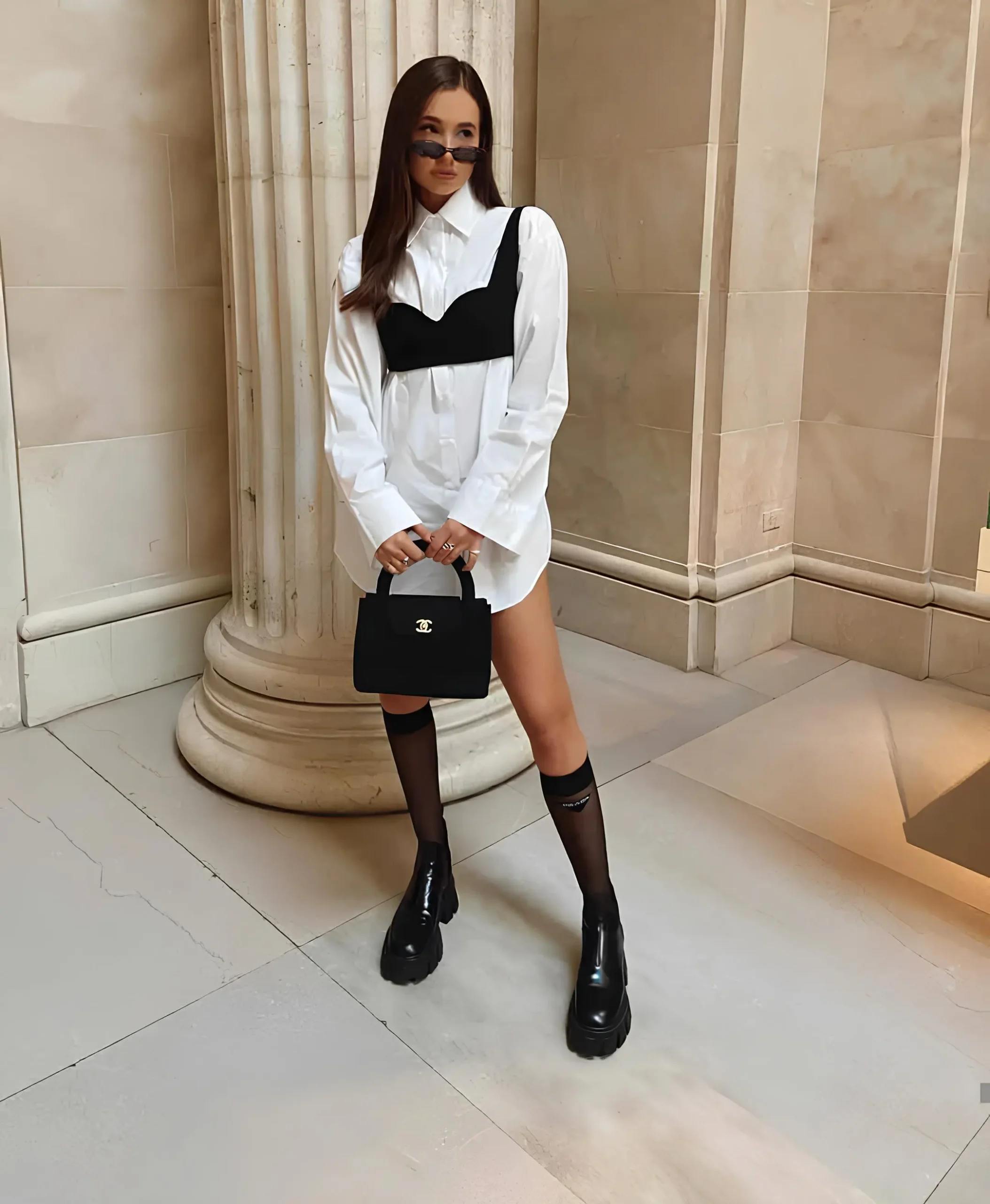 modelo usando camisa branca oversized e um cropped preto para marcar o busto