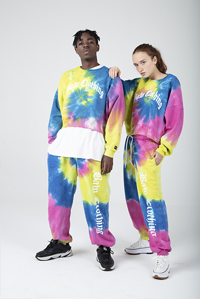 Casal usando roupas tie-dye coloridas e modernas.