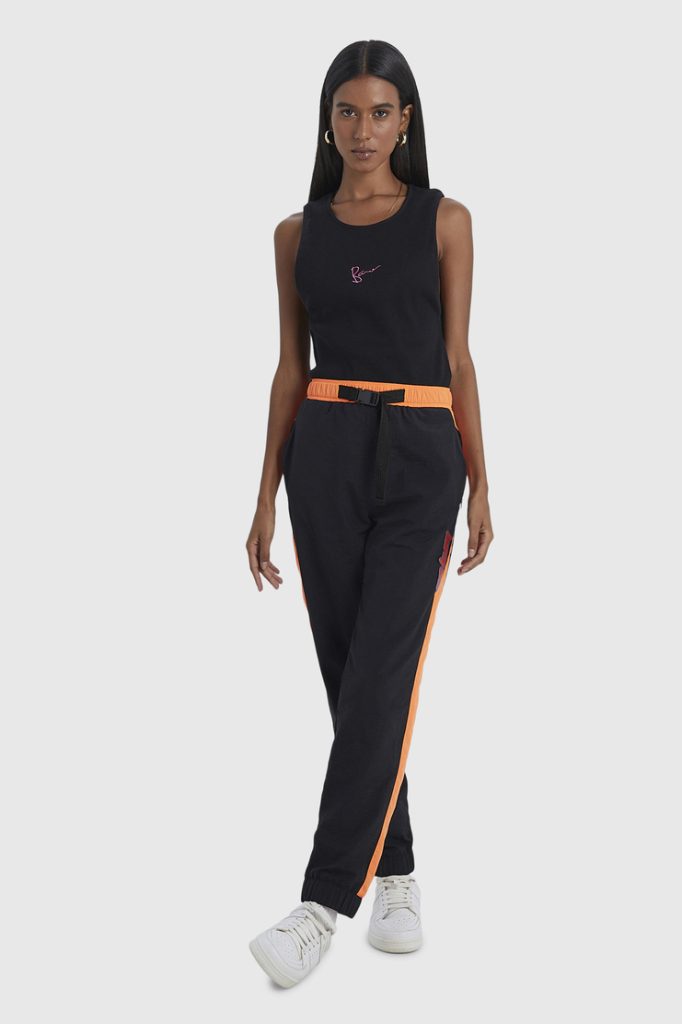 Mulher vestindo conjunto preto com detalhes laranja