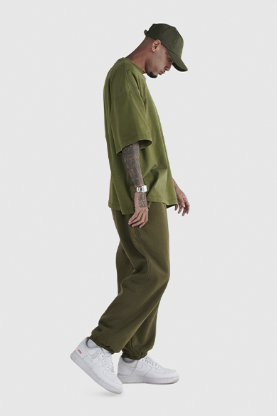 Homem usando conjunto verde com tênis brancos.