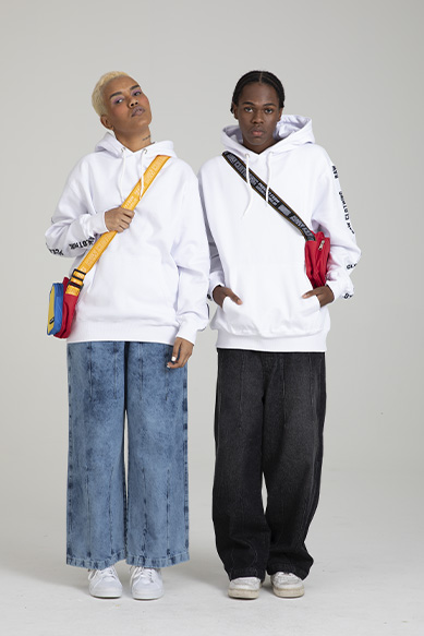 Duas pessoas usando moletom branco e jeans largos