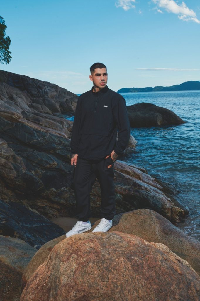Homem em roupa esportiva na praia rochosa