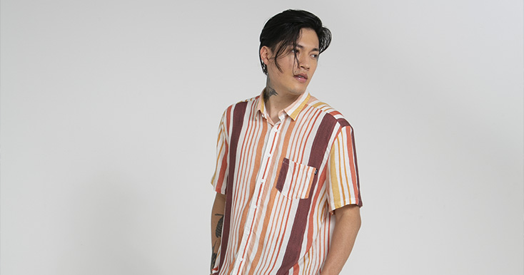 Jovem homem usando camisa listrada colorida