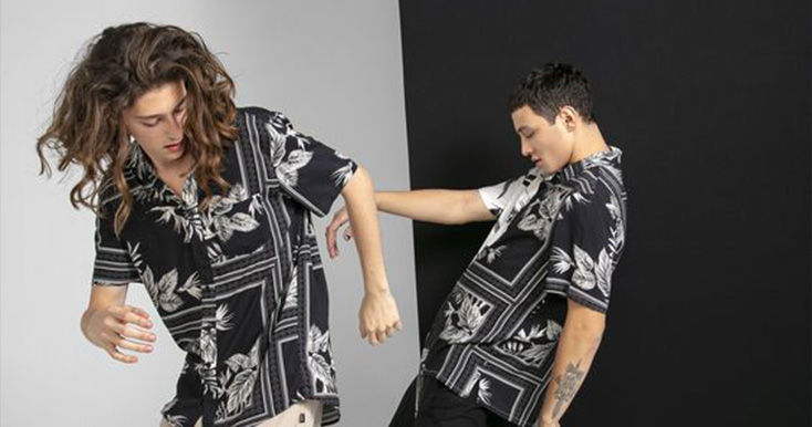 Dois jovens usando camisas florais em fundo neutro