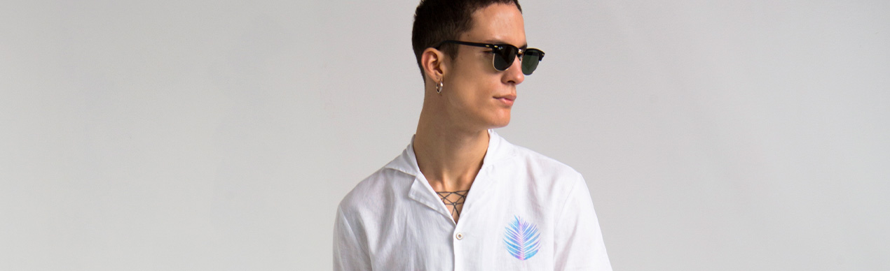 Modelo usando camisa branca com óculos escuros
