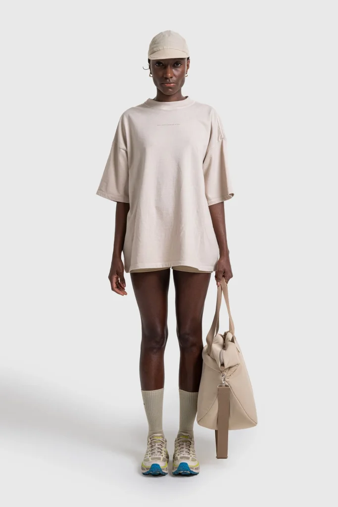 Modelo feminino com look casual e bolsa moderna.