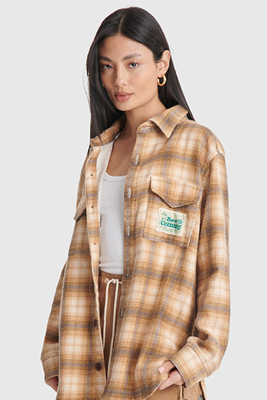 Modelo usando camisa xadrez em tons terrosos