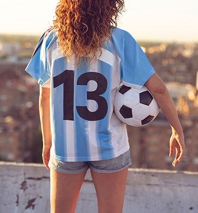 Jovem vestindo camisa da Argentina com bola de futebol