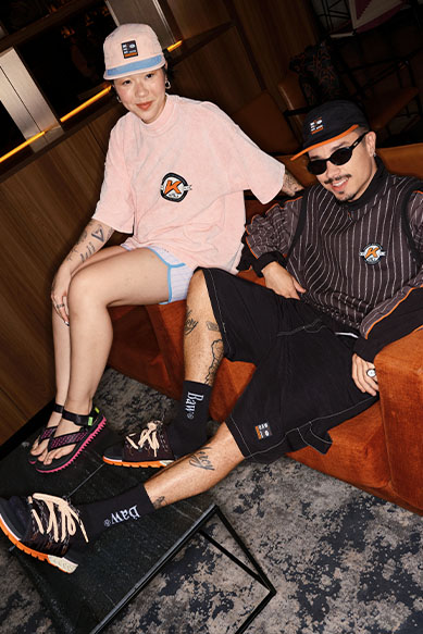 Casal em roupa casual, sentados em sofá estiloso.