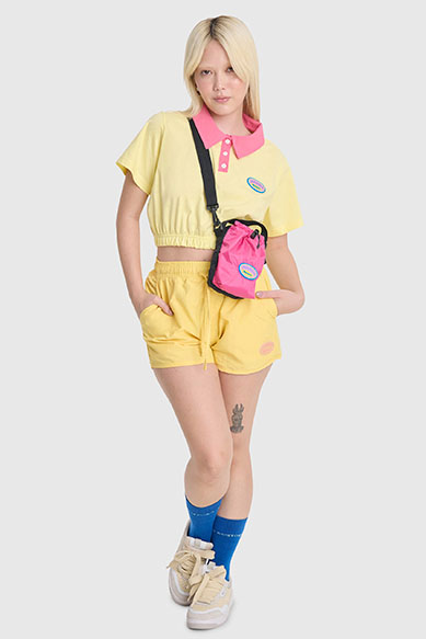Modelo vestindo conjunto casual amarelo e bolsa colorida