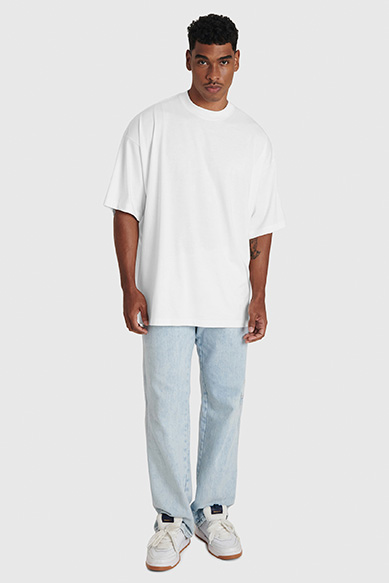 Homem usando camiseta branca e jeans claros.