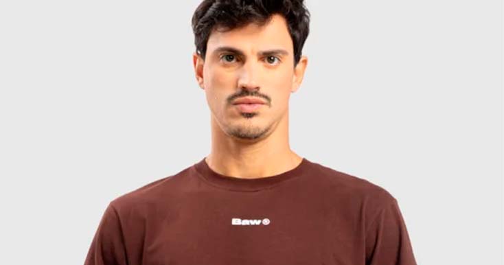Homem com camiseta marrom e expressão neutra