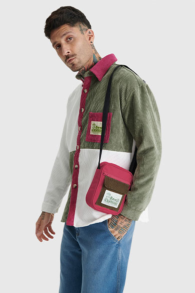 Homem usando camisa colorida e bolsa tiracolo.