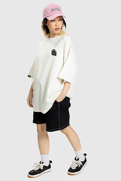 Jovem vestindo camiseta oversized e boné rosa