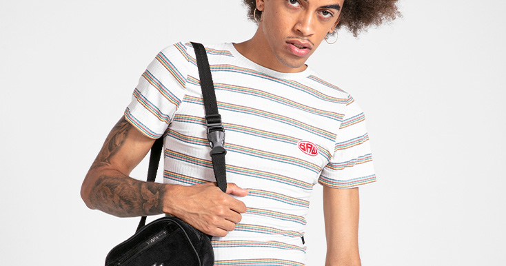 Homem jovem vestindo camiseta listrada com bolsa