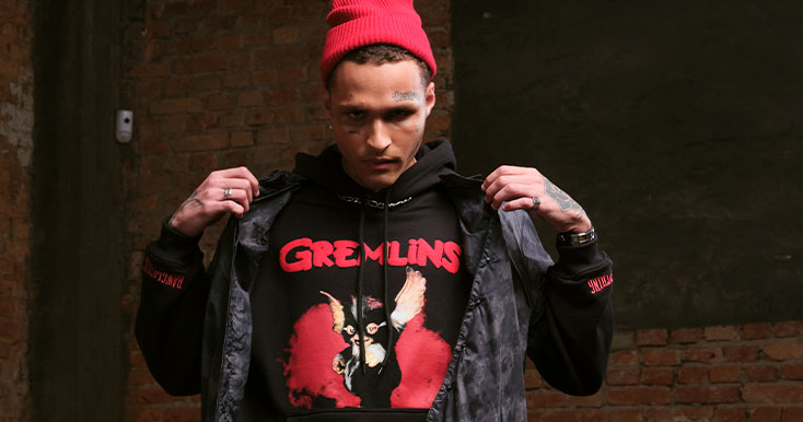 Jovem usando moletom dos Gremlins com gorro vermelho.