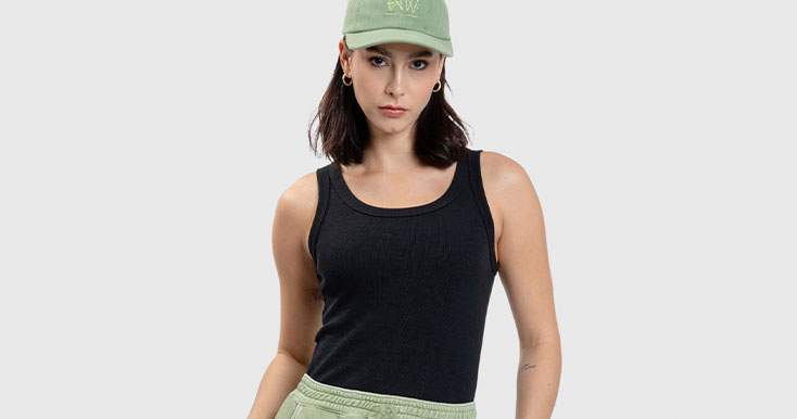 Jovem mulher com blusa preta e boné verde