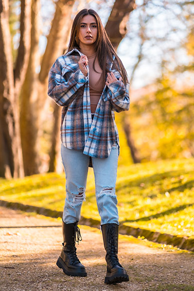 Jovem mulher usando camisa xadrez em parque
