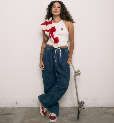 jovem mulher estilosa com skate e roupas casuais