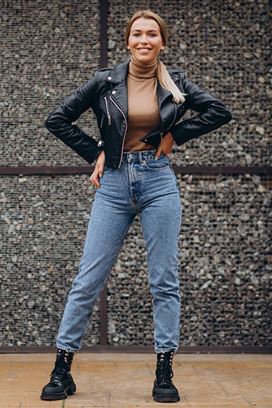 Jovem mulher com jaqueta de couro e jeans