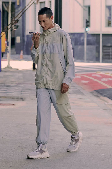 Jovem vestido com roupa esportiva leve na rua.