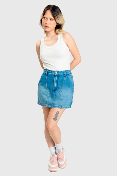 Jovem posando com saia jeans e camiseta branca