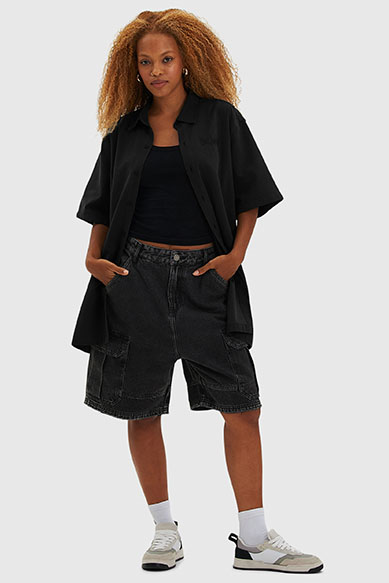 Mulher com cabelo cacheado em look casual com shorts