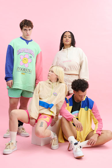 Modelo jovem exibindo moda casual colorida em fundo rosa