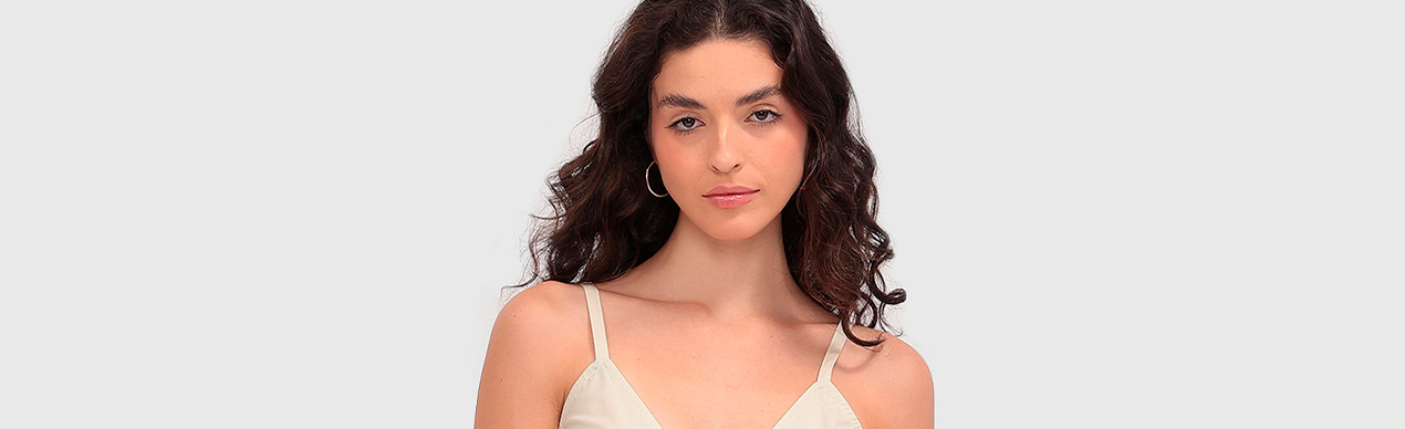 Modelo com blusa clara e cabelo ondulado