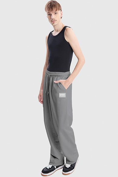 Modelo vestindo calça cinza e regata preta