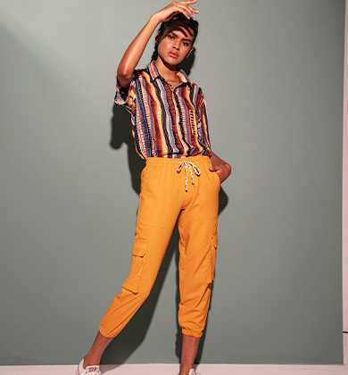 Modelo com camisa listrada e calça amarela casual