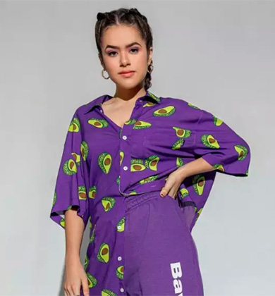 Modelo usando camisa roxa com estampa de abacate.