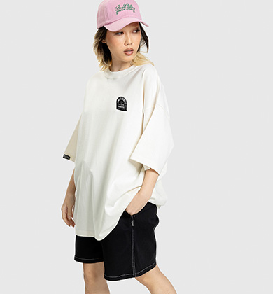 Modelo com camiseta oversized branca e boné rosa