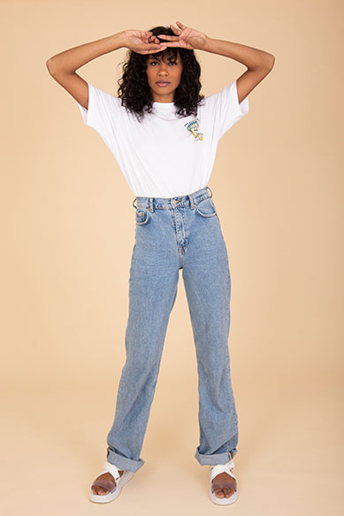 Modela usando camiseta branca e jeans claro