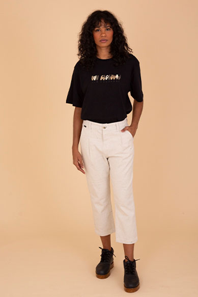 Modelo feminina usando camiseta preta e calça clara