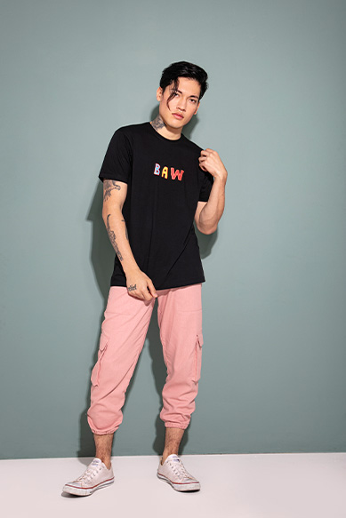 Modelo com camiseta preta e calça rosa