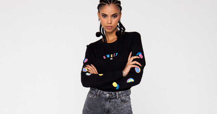 Modelo usando camiseta preta com estampas coloridas