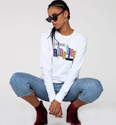 Modelo feminina com camiseta estilosa e óculos escuros.