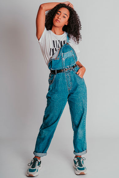 Modelo com macacão jeans e camiseta branca