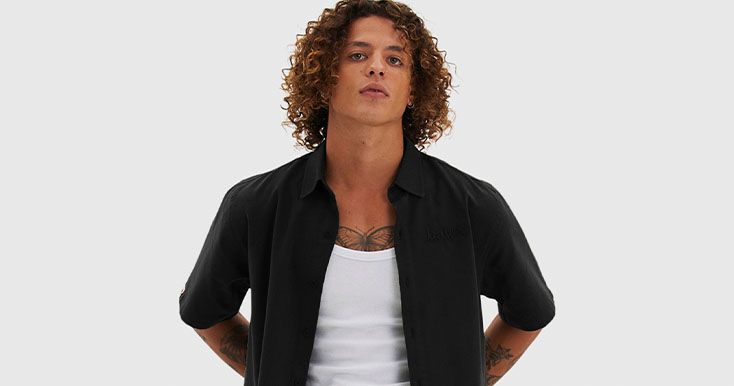 Modelo masculino com cabelos cacheados e camisa preta