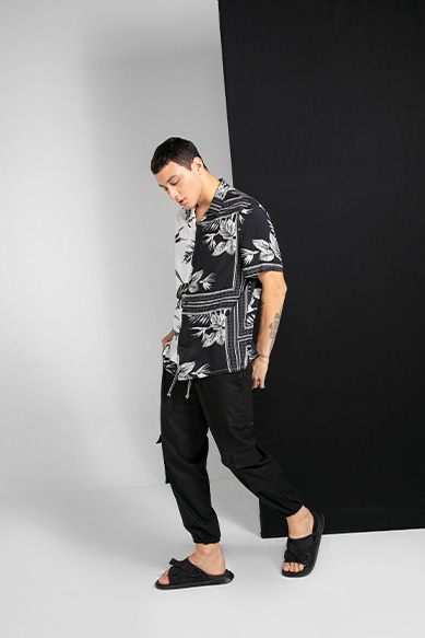 Modelo masculino com camisa estampada em fundo neutro