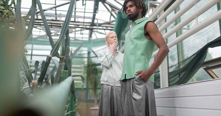 Modelo masculino com roupa verde em estufa com plantas