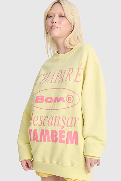 Moça usando moletom amarelo com estampa rosa