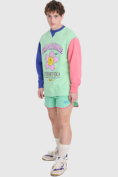 Homem jovem vestido com moletom colorido e bermuda