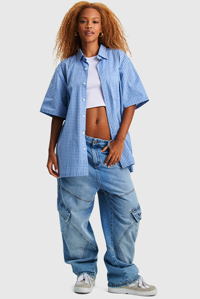 Mulher com blusa xadrez e calça jeans larga