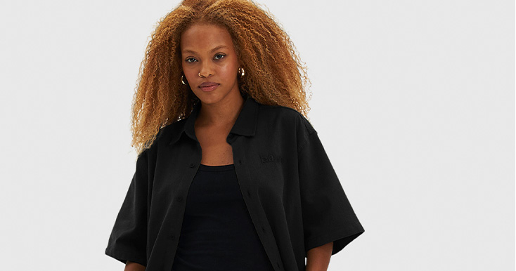 Mulher com cabelo cacheado usando camisa preta